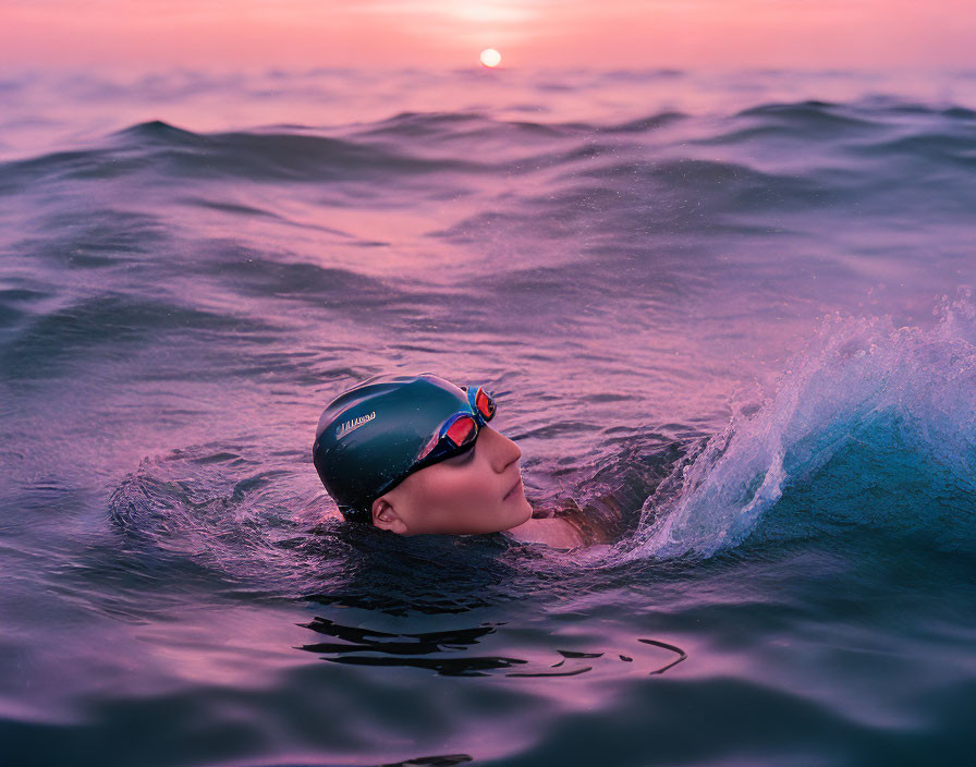 Swimmer with Goggles and Cap in Ocean at Sunset with Water Splash and Calm Waves