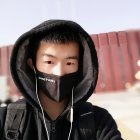 Digital artwork of person in black hoodie, mask, and earphones