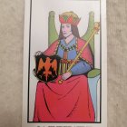 Tarot card with robed figure holding pentacle & golden designs