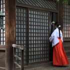 Traditional kimono-clad woman by Japanese house with garden, lantern, and pagoda