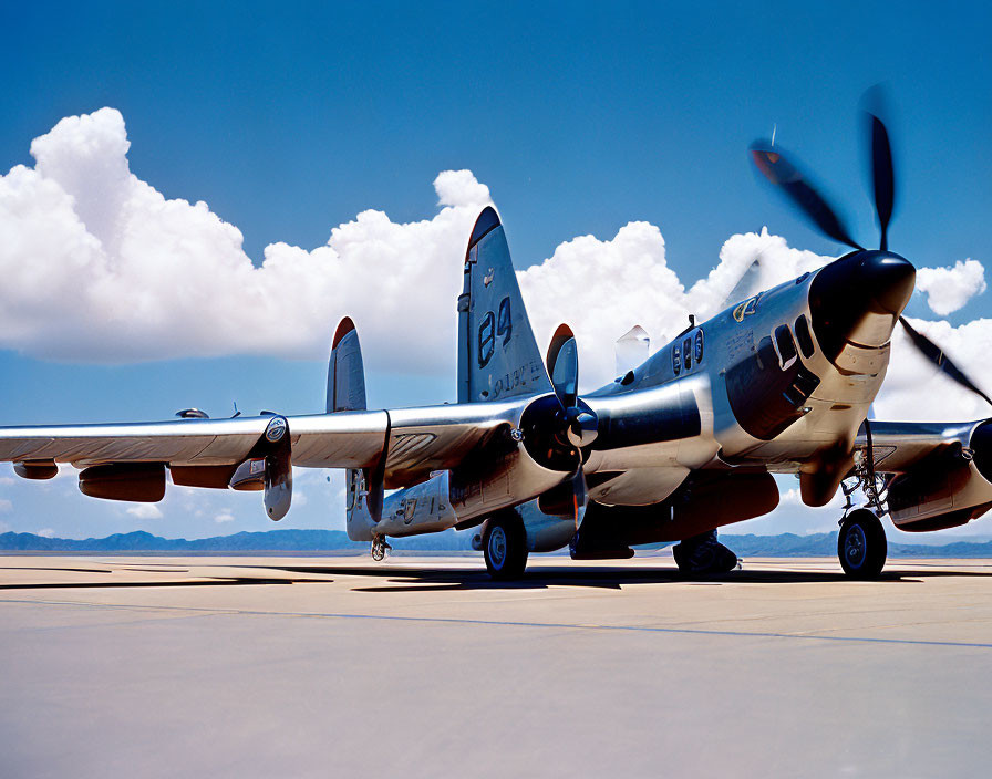 Vintage Twin-Propeller Fighter Aircraft on Tarmac under Blue Sky