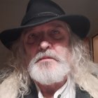 Elder Man in Steampunk Attire with Tricorner Hat and White Beard