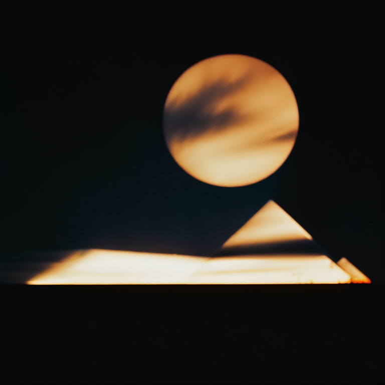 Blurred moon over pyramid silhouette in warm glow
