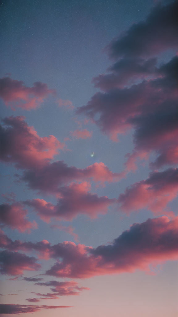 Tranquil sunset sky with pink clouds and early stars on deepening blue gradient