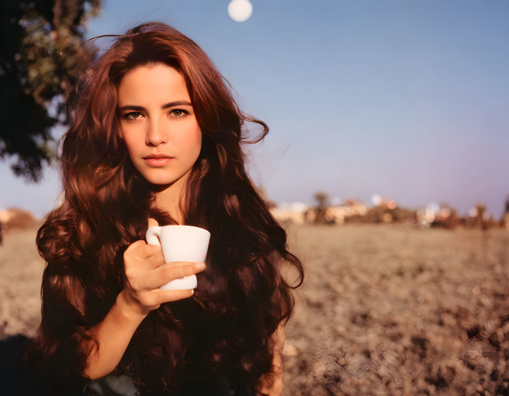 Woman with Long Brown Hair Holding White Cup Outdoors at Twilight