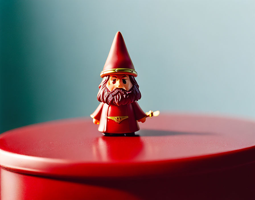Red-hat Gnome Figurine with Golden Trumpet on Red Surface