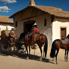 Traditional Attire Horseback Riders by Adobe Building
