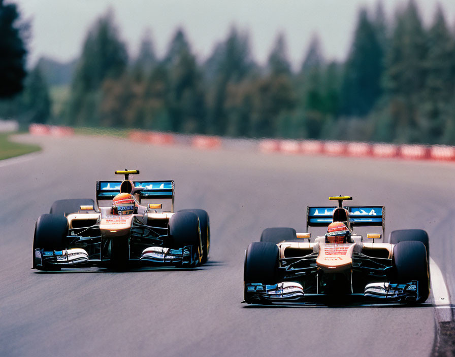 Two Formula 1 Cars Racing on Track with Trees