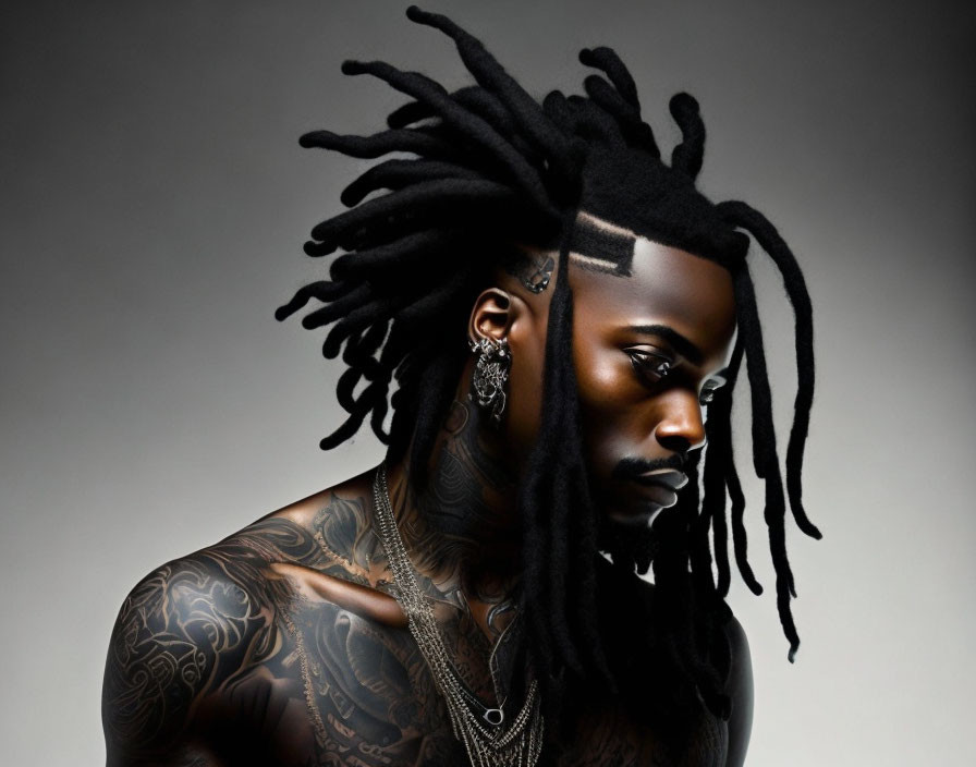 Tattooed person with dreadlocks and patterned hairline portrait