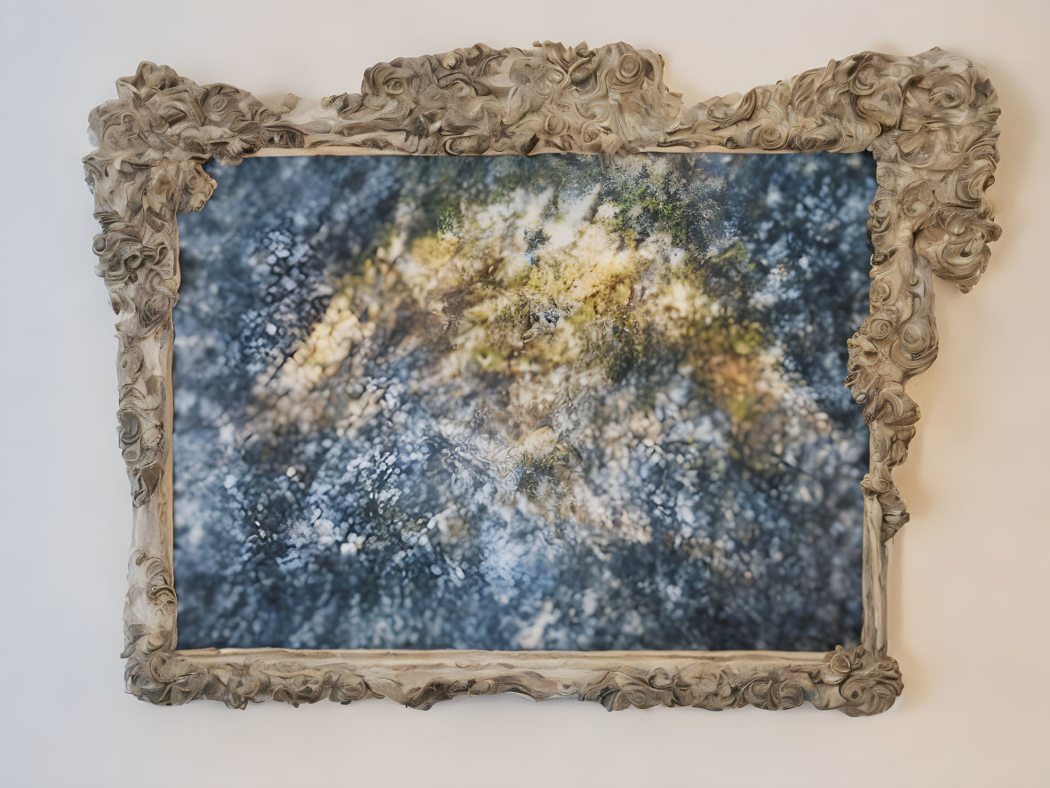 Baroque-style frame surrounding abstract blue and gold textured image.