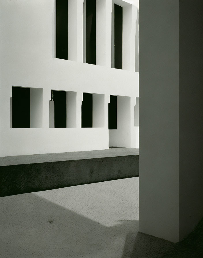 Monochrome photograph of building corner with geometric shadows