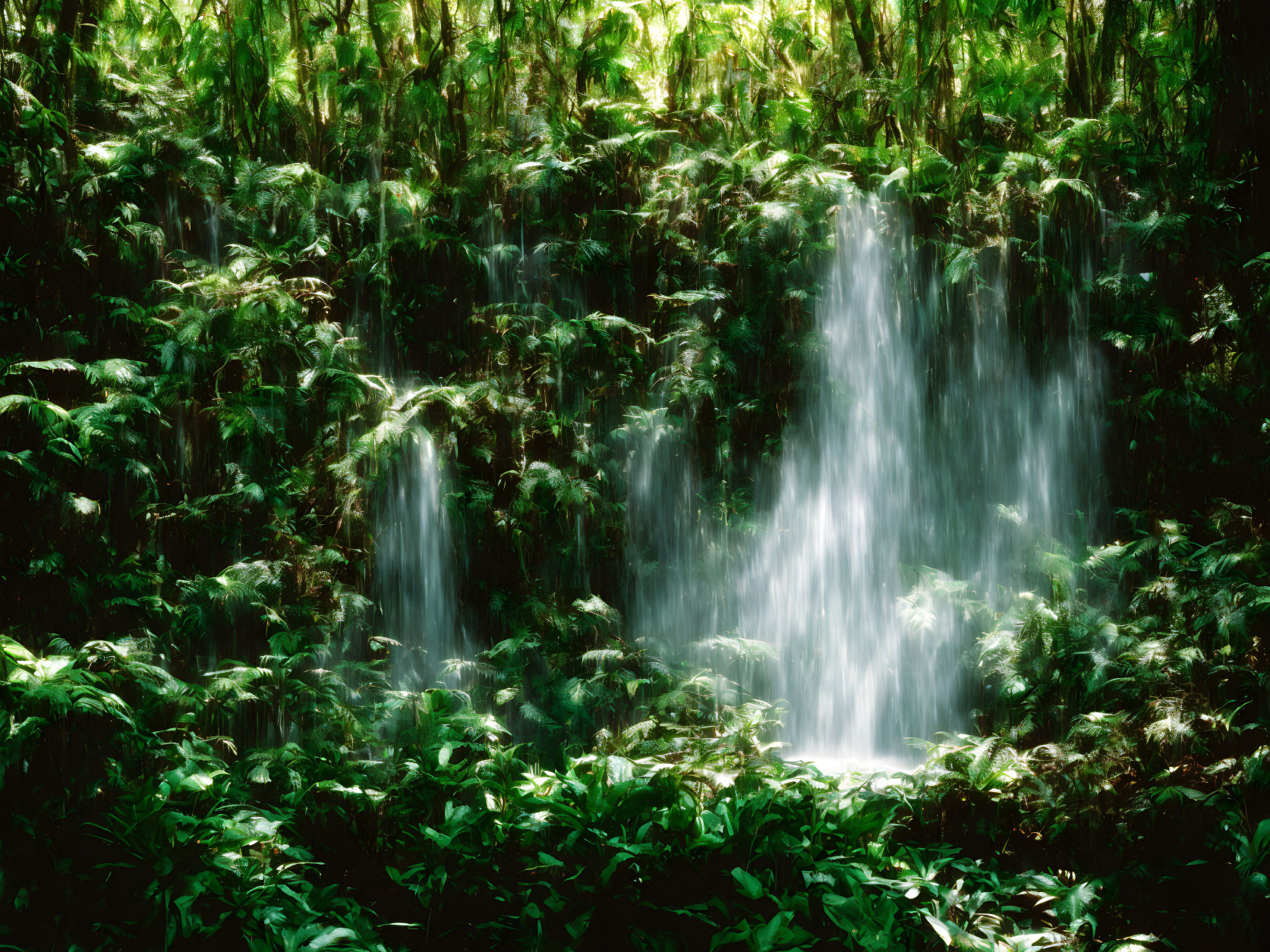 Tranquil waterfall in lush green forest landscape