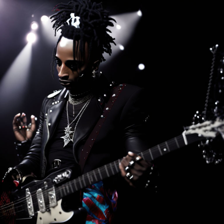 Musician with dreadlocks in studded leather jacket plays guitar on stage
