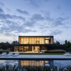 Contemporary Two-Story House with Poolside Lounge, Garden, and Illuminated Interior