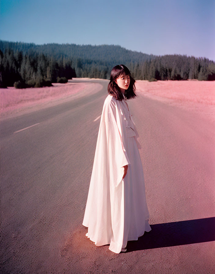 Woman in White Cloak on Deserted Road in Forest Clearing