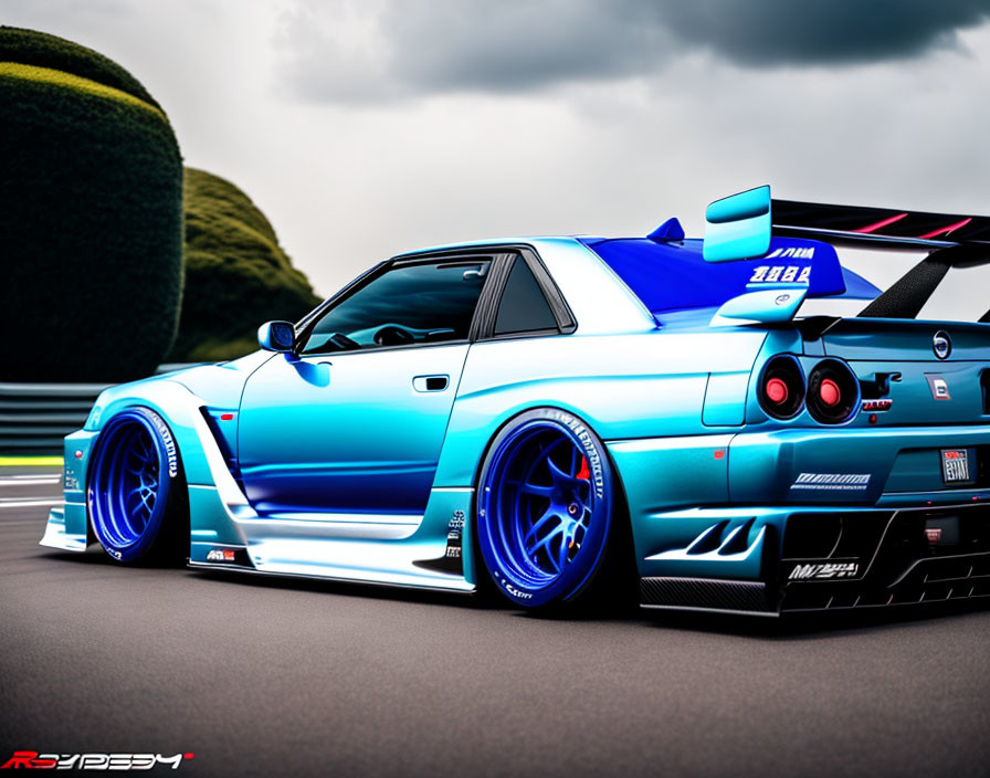Blue Wide Body Kit Sports Car with Aftermarket Wheels and Large Rear Wing on Track Under Cloudy Sky