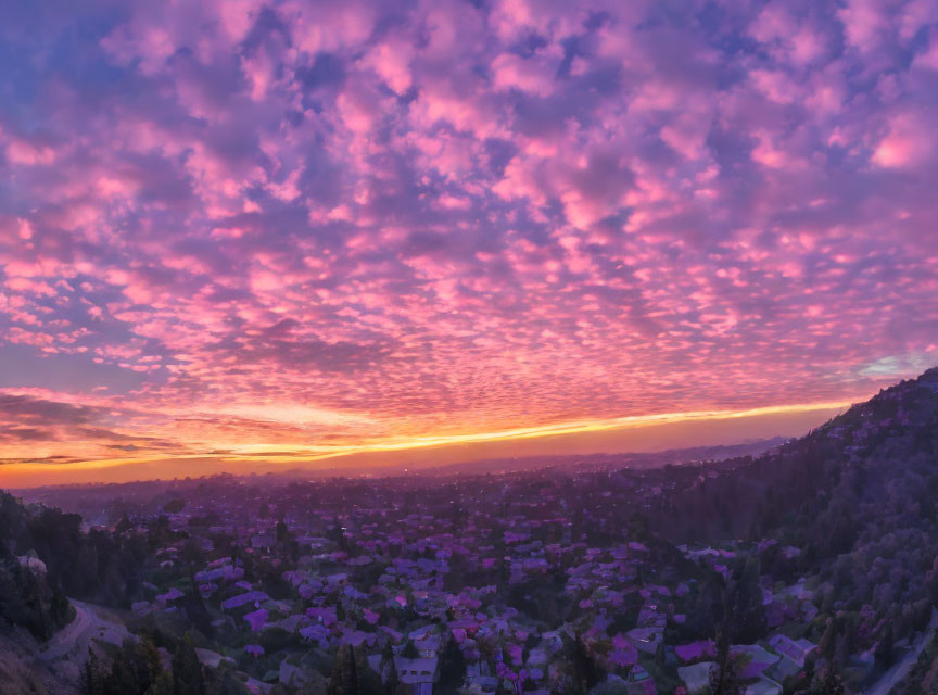 Colorful sunrise over peaceful town with scattered houses.