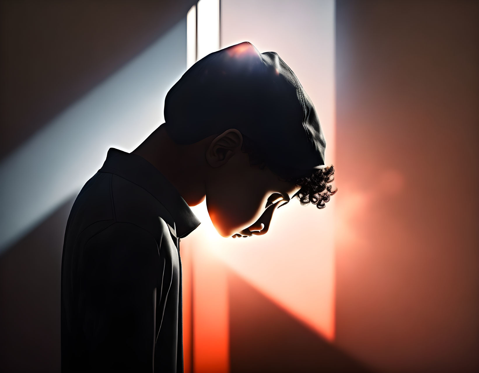 Silhouette of person with curly hair in cap and shirt against moody backdrop