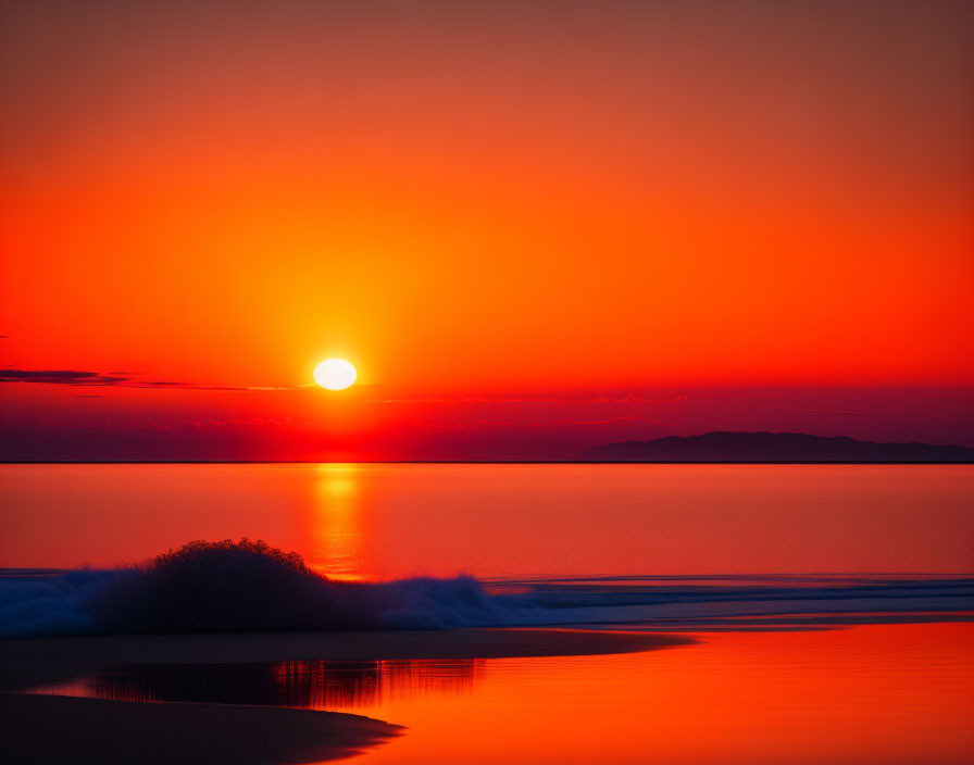 Intense orange and red sunset over ocean waves