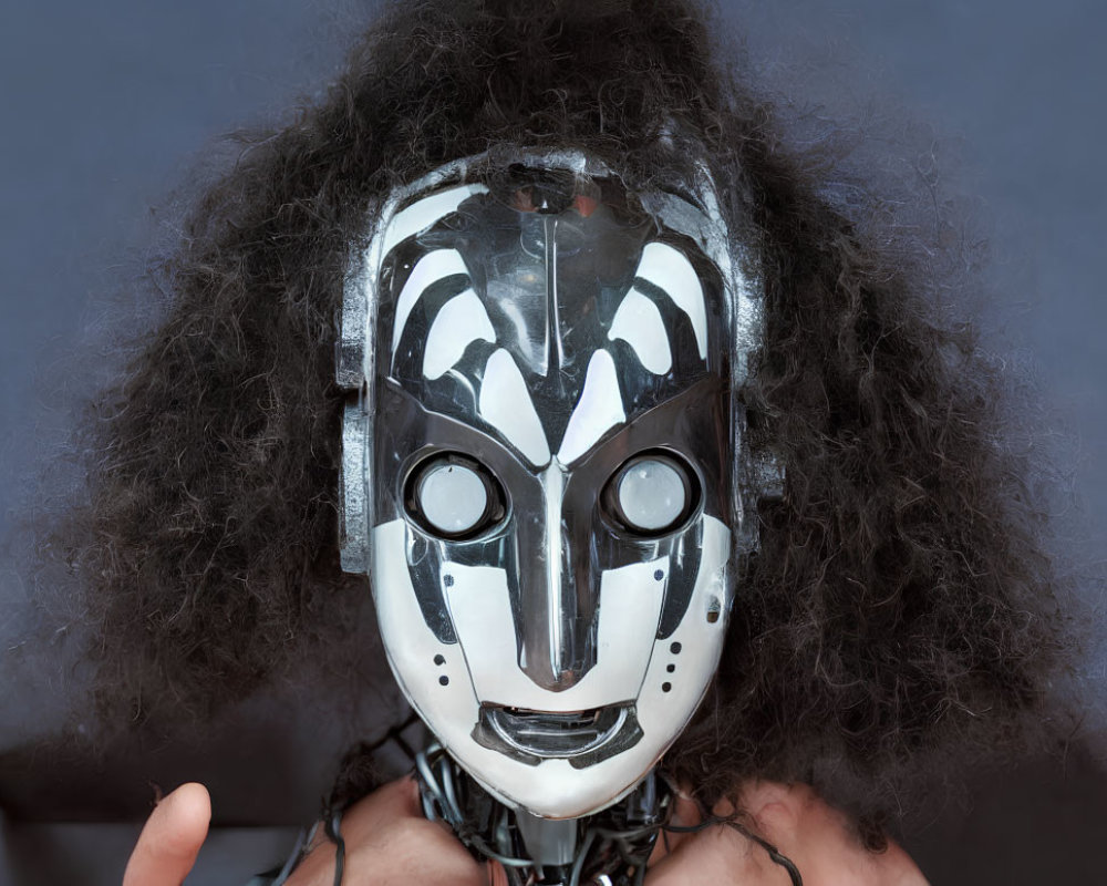 Futuristic silver mask with intricate designs and frizzy dark hairstyle