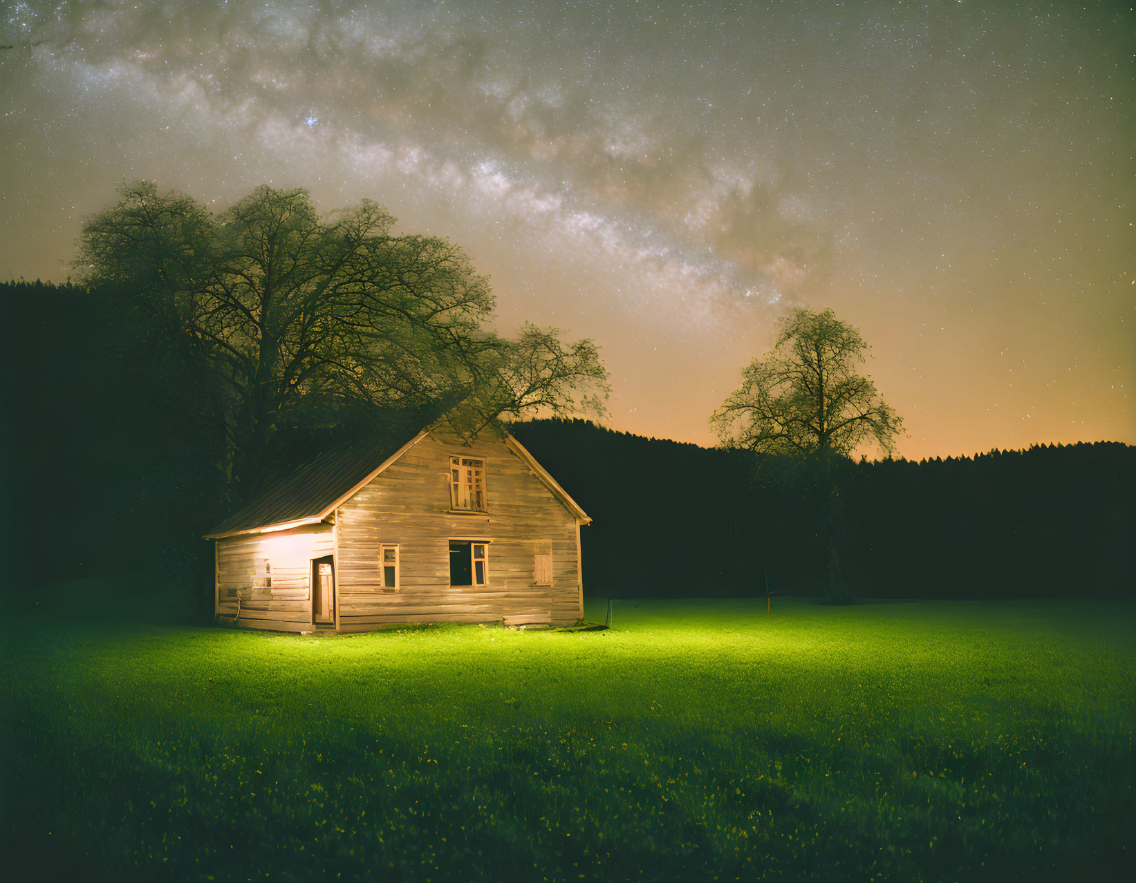 Wooden house under starry sky with Milky Way, forest landscape