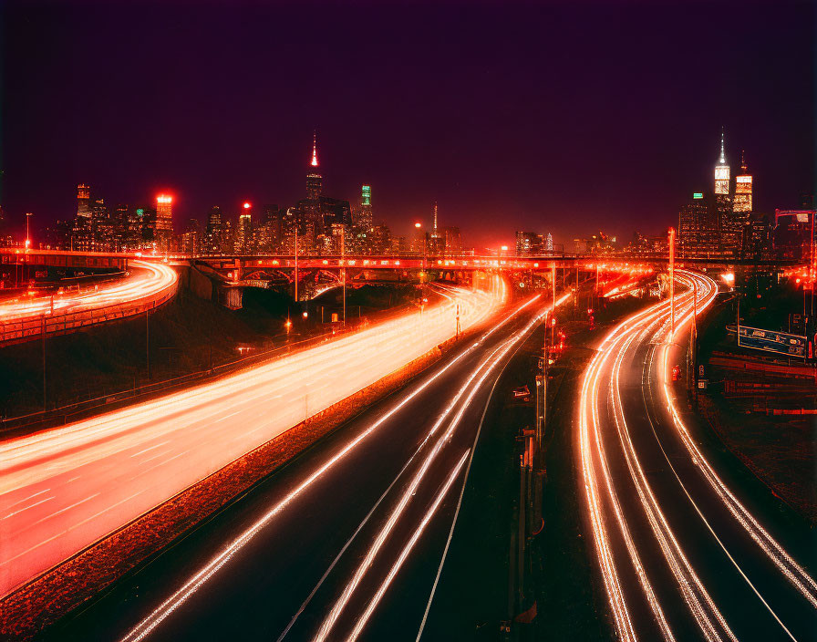 Urban night scene with glowing skyscrapers and busy highway light trails