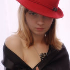 Blonde woman in red hat and black outfit with gold details