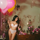 Woman in lingerie surrounded by colorful balloons and flowers in ornate room