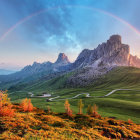 Scenic winding road through golden fields with majestic mountains and rainbow