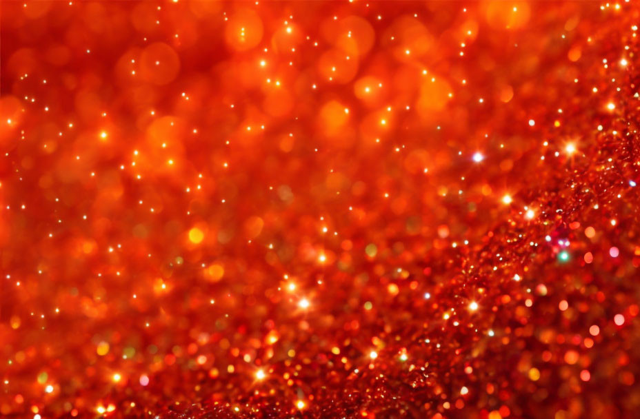 Close-up Image of Red and Orange Glitter Sparkling with Light Reflections