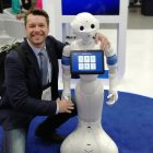 Businessman shaking hands with humanoid robot in modern setting