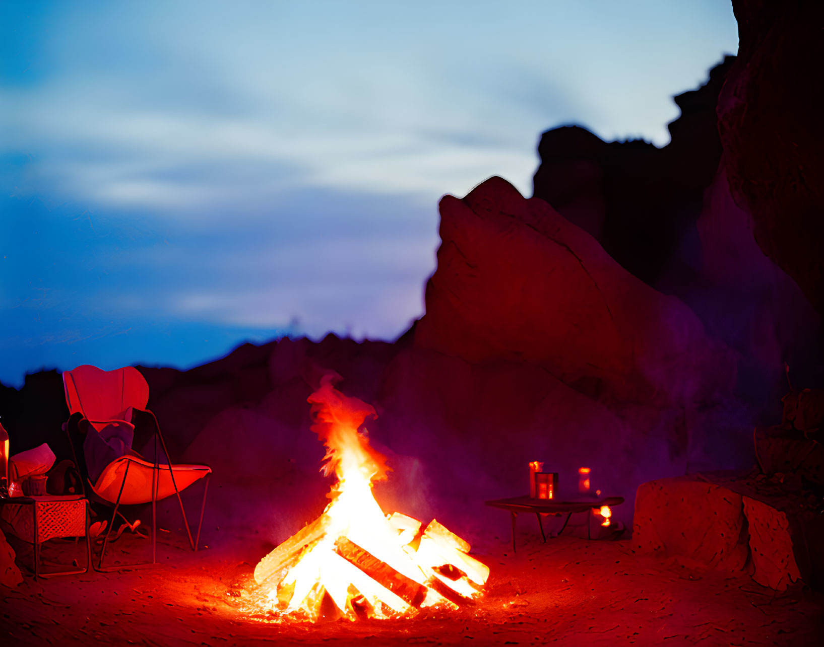 Vibrant dusk campfire with chair and supplies against rocky backdrop