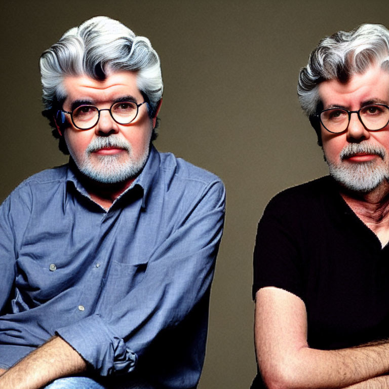 Two gray-haired men with beards and glasses in blue and black shirts on gray background