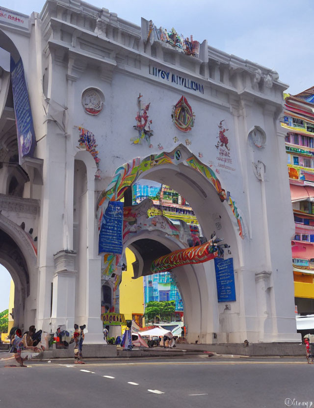 White Archway with Colorful Decorations and Vibrant Building Beyond