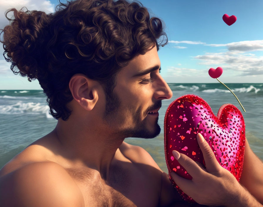 Curly-Haired Man Smiles with Heart Cushion at Beach