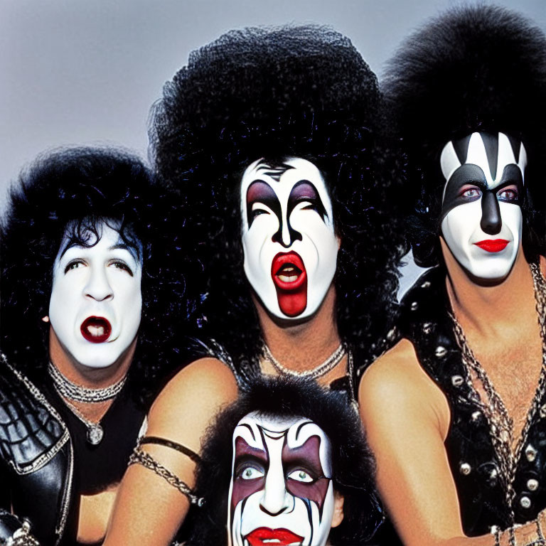 Four individuals with black and white face paint and flamboyant hair resembling rock band members.