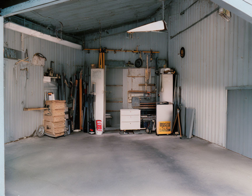 Empty Garage with a roll-up door and tools hanging