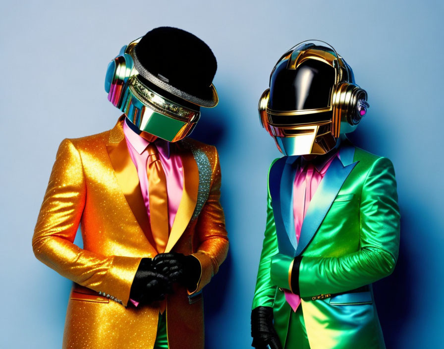 Two individuals in shiny gold and green suits with futuristic helmets on blue background.