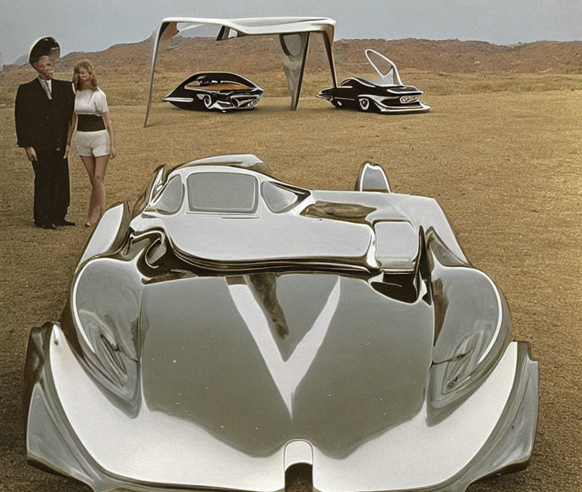 Man and woman with futuristic concept cars in desert setting