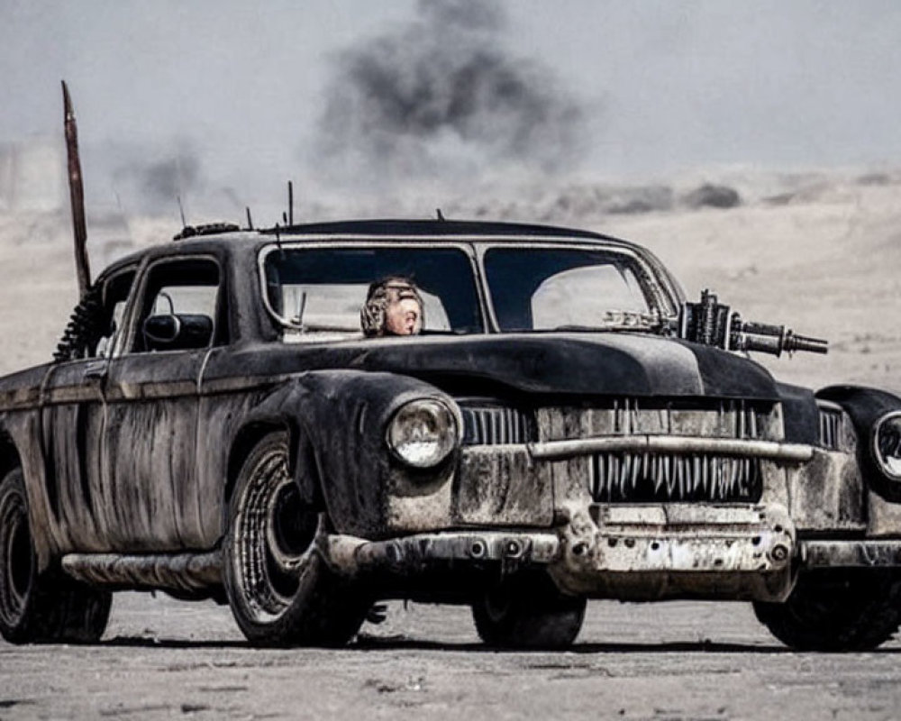 Vintage car with mounted gun driving through barren landscape