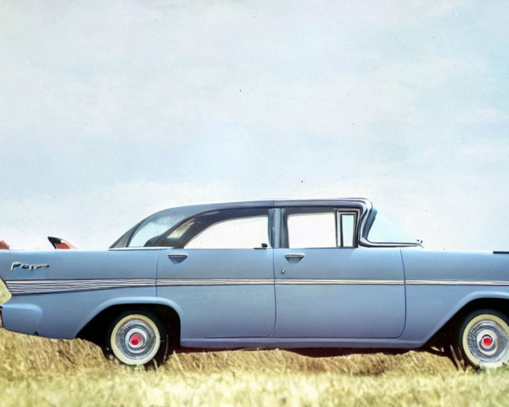 Vintage Blue Car Parked on Grass with Person by Open Trunk