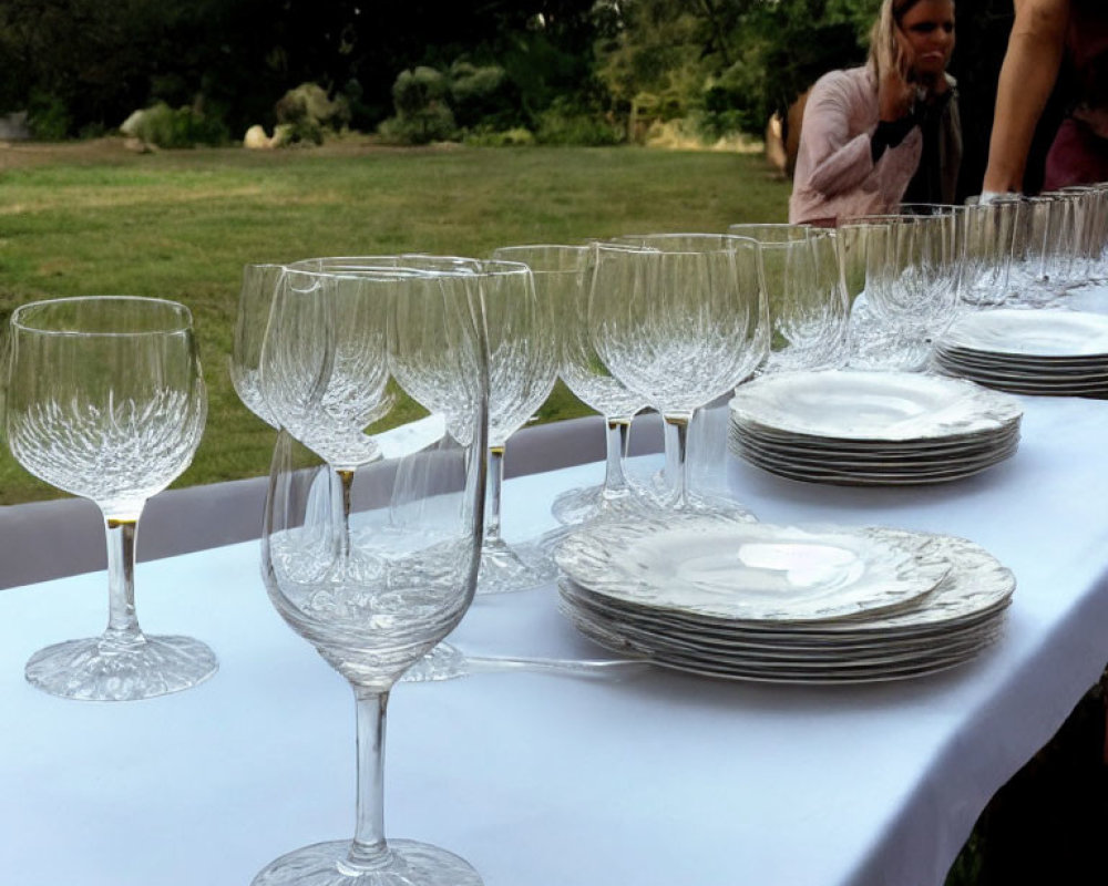 Outdoor Event Table Setting with Wine Glasses and Stacked Plates