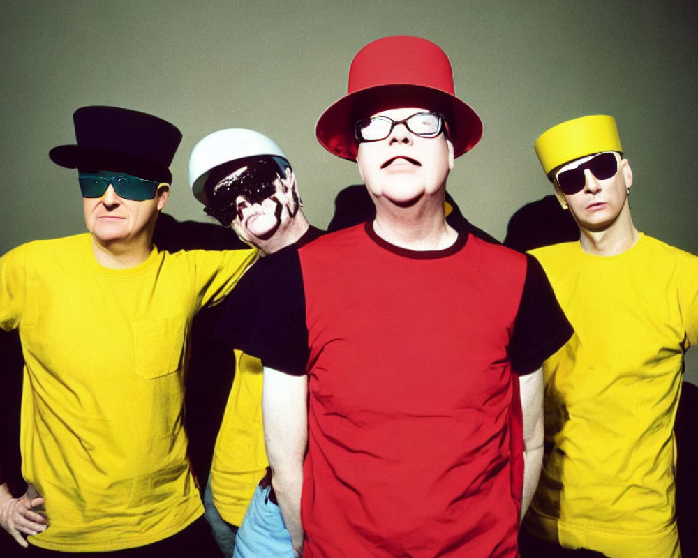 Four People in Bright Yellow T-Shirts and Colorful Hats on Green Background