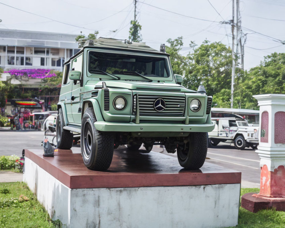 Green Mercedes-Benz G-Class SUV on Roadside Pedestal in Clear Day