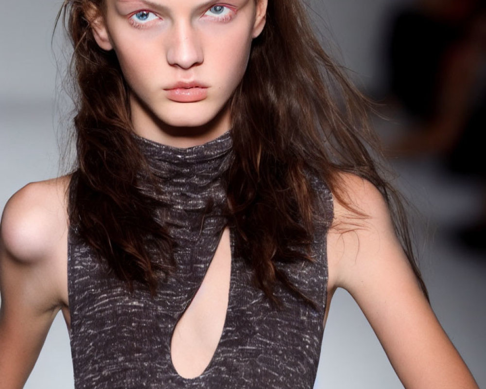 Person with Blue Eyes in Gray Sleeveless Top Struts Runway
