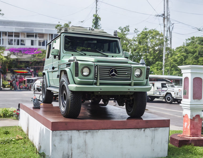 Green Mercedes-Benz G-Class SUV on Roadside Pedestal in Clear Day