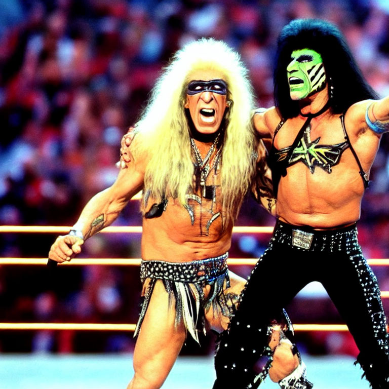Colorful face paint and flamboyant costumes: Professional wrestlers posing in a wrestling ring.