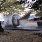 Spiral-shaped concrete sculpture in twilight park setting