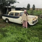 Vintage Silver Car with Golden Headlights Parked on Grass Field