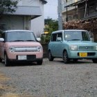 Colorful compact cars parked in front of traditional Japanese houses on residential street